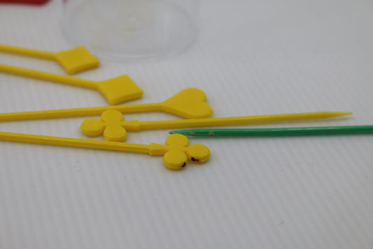 7 Vintage Hard Plastic Toothpicks and a plastic cake axe playing cards logo