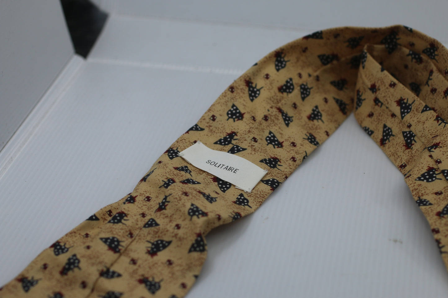 Tie Solitaire with rooster birds logo on a beige cloth